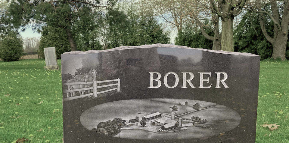 My grandparents' headstone in Rock Chapel Cemetery, with the name 'Borer' prominently featured, along with an engraving of our family farm.